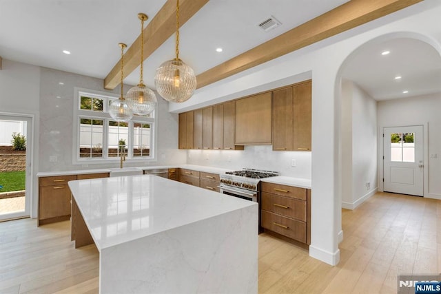 229 Bogert Pl, Paramus, NJ 07652 - kitchen featuring light wood-style floors, appliances with stainless steel finishes, brown cabinets, and visible vents