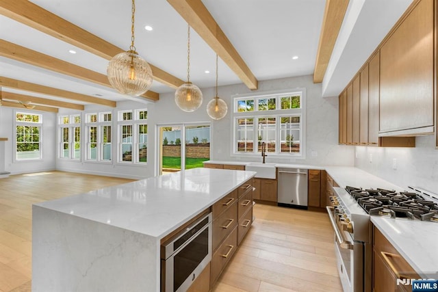 229 Bogert Pl, Paramus, NJ 07652 - kitchen with light stone countertops, appliances with stainless steel finishes, beam ceiling, a sink, and a kitchen island