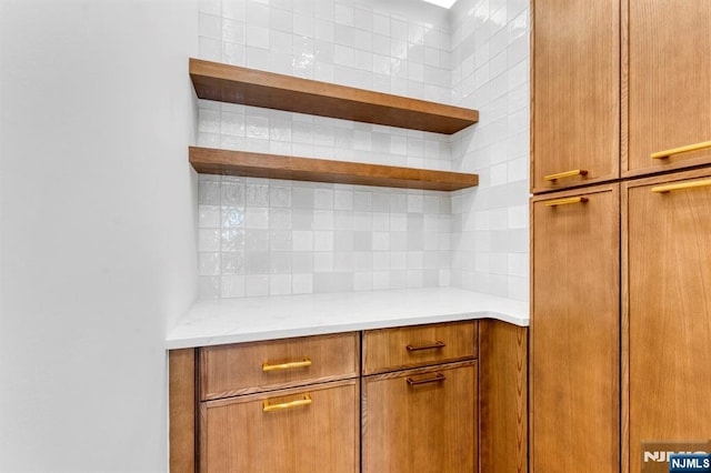 229 Bogert Pl, Paramus, NJ 07652 - kitchen featuring open shelves, backsplash, brown cabinets, and light stone countertops