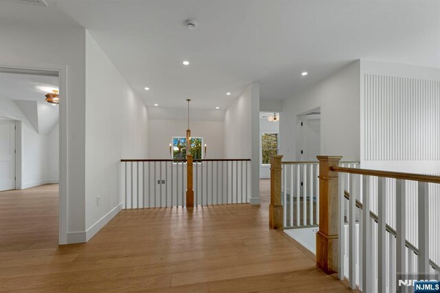 229 Bogert Pl, Paramus, NJ 07652 - hall with light wood-style floors, baseboards, recessed lighting, a notable chandelier, and an upstairs landing