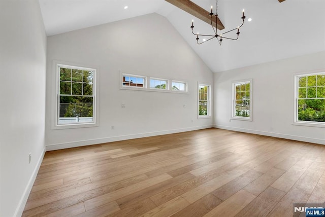 229 Bogert Pl, Paramus, NJ 07652 - unfurnished living room featuring high vaulted ceiling, a notable chandelier, baseboards, and light wood-type flooring