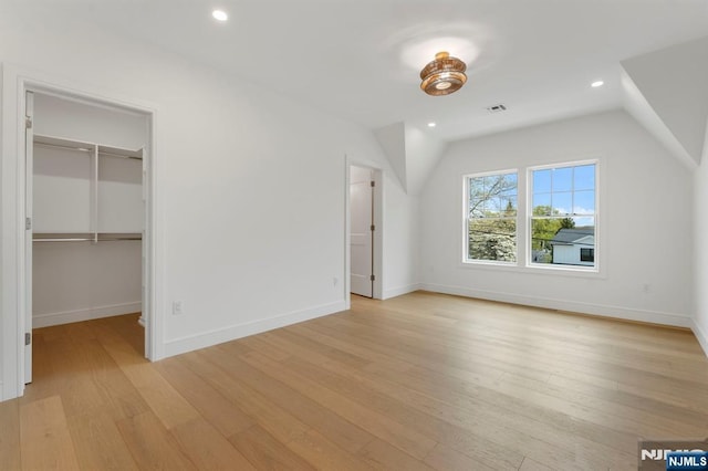 229 Bogert Pl, Paramus, NJ 07652 - unfurnished bedroom featuring visible vents, vaulted ceiling, baseboards, light wood finished floors, and a spacious closet