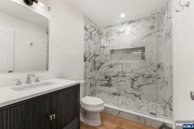 229 Bogert Pl, Paramus, NJ 07652 - bathroom featuring wood finished floors, vanity, toilet, a marble finish shower, and recessed lighting