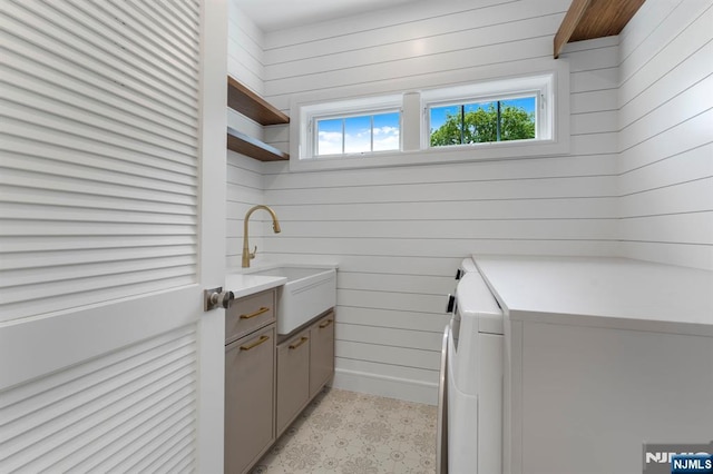 229 Bogert Pl, Paramus, NJ 07652 - laundry area featuring a sink, wood walls, washer / dryer, and a healthy amount of sunlight