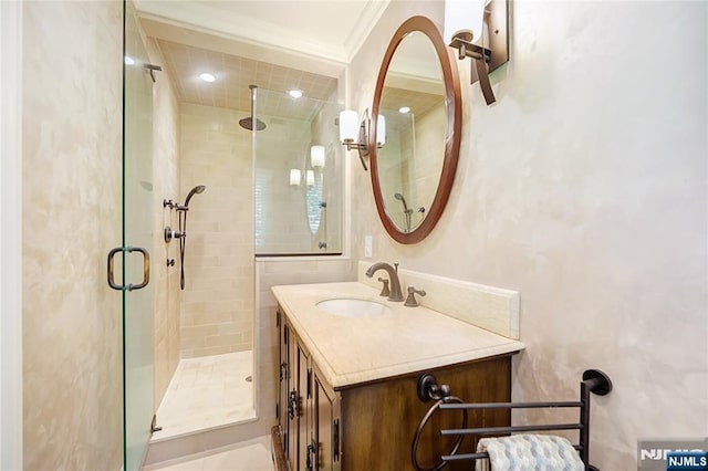 full bathroom with crown molding, a shower stall, and vanity