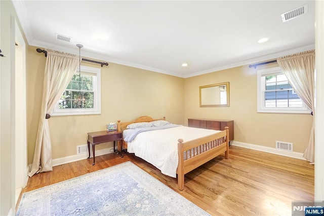 bedroom with baseboards, wood finished floors, and visible vents