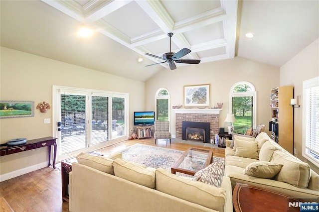 living room featuring ceiling fan, lofted ceiling with beams, a brick fireplace, and wood finished floors