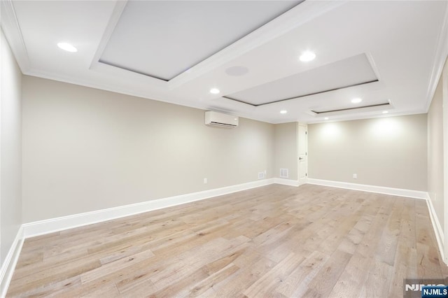 below grade area featuring crown molding, baseboards, a wall mounted air conditioner, recessed lighting, and light wood finished floors