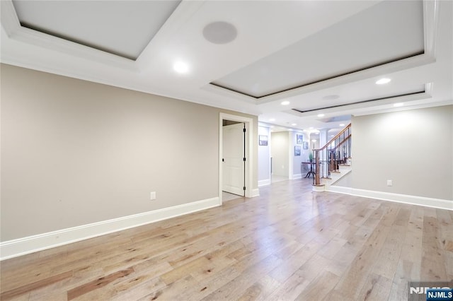 below grade area with crown molding, baseboards, stairway, recessed lighting, and light wood-type flooring