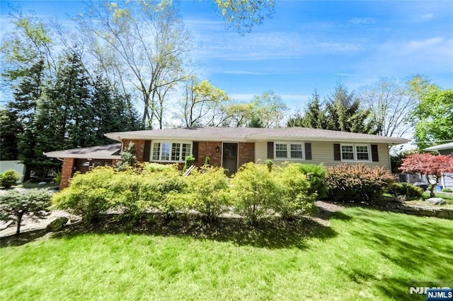 ranch-style home featuring brick siding and a front lawn