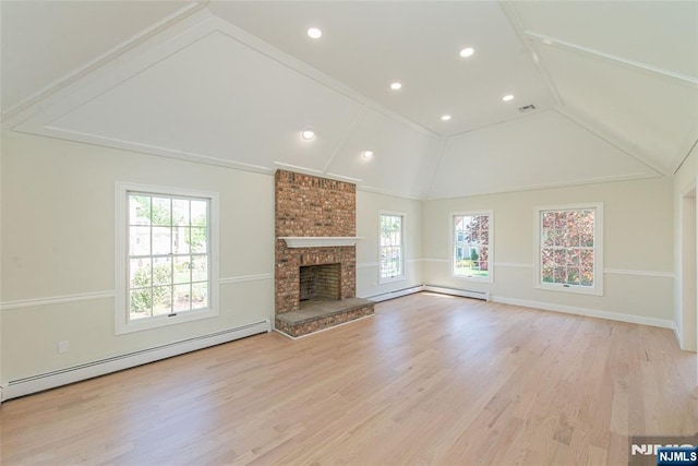 unfurnished living room featuring plenty of natural light, baseboard heating, a brick fireplace, and lofted ceiling