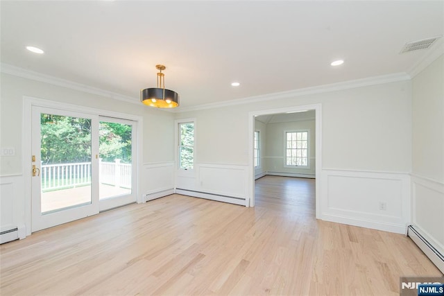 unfurnished room with visible vents, a wealth of natural light, baseboard heating, and a baseboard radiator