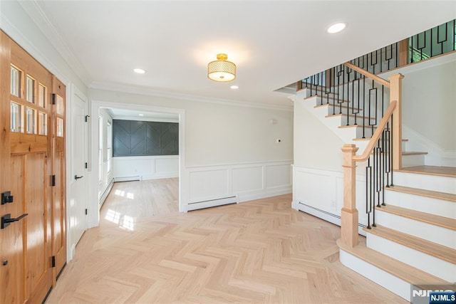 interior space with crown molding, wainscoting, a decorative wall, stairs, and a baseboard radiator