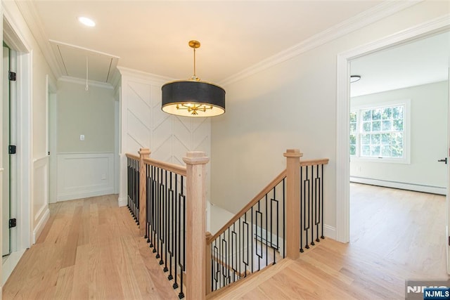 hallway with wood finished floors, attic access, a baseboard heating unit, and an upstairs landing