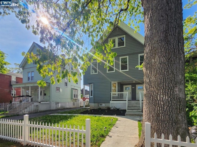 view of front of house featuring covered porch, stairway, and fence private yard