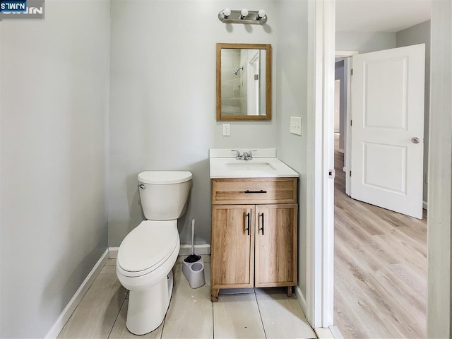 bathroom featuring baseboards, a shower, toilet, and vanity