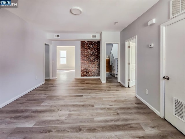 unfurnished living room with visible vents and wood finished floors