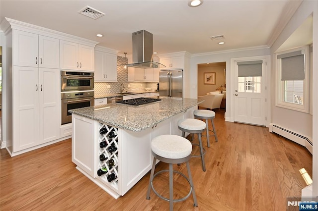 kitchen with island range hood, a center island, white cabinets, a baseboard heating unit, and stainless steel appliances