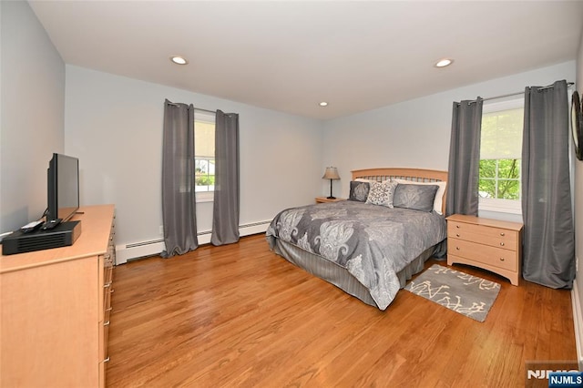 bedroom with light wood-style floors, a baseboard radiator, recessed lighting, and multiple windows