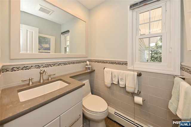 bathroom featuring visible vents, tile walls, a wainscoted wall, vanity, and toilet