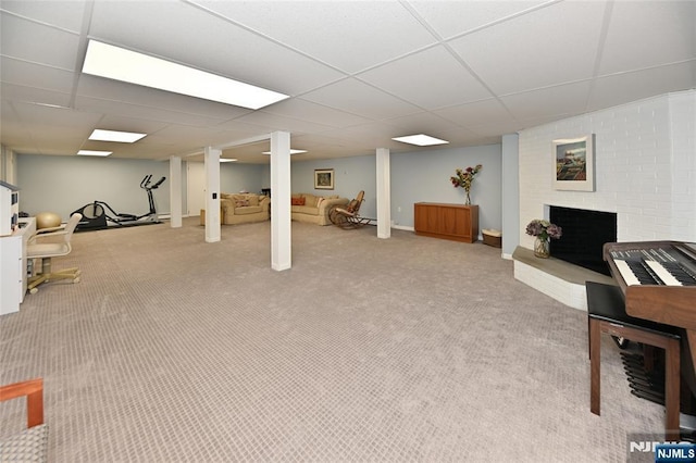 finished below grade area featuring baseboards, carpet, a brick fireplace, and a drop ceiling