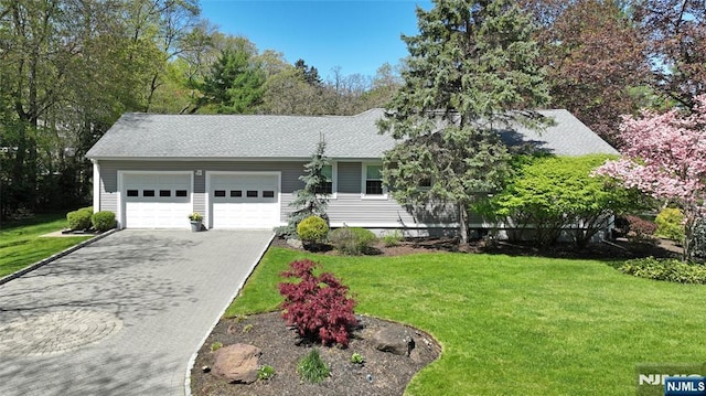 ranch-style house with roof with shingles, an attached garage, driveway, and a front lawn