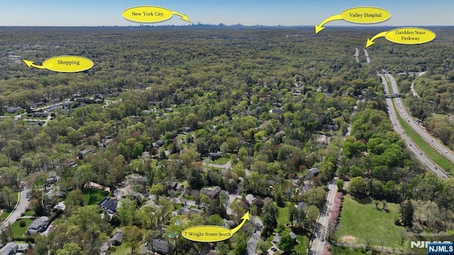 birds eye view of property featuring a view of trees