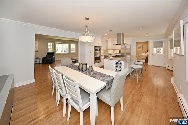 dining room with a baseboard radiator, light wood-style flooring, and ornamental molding