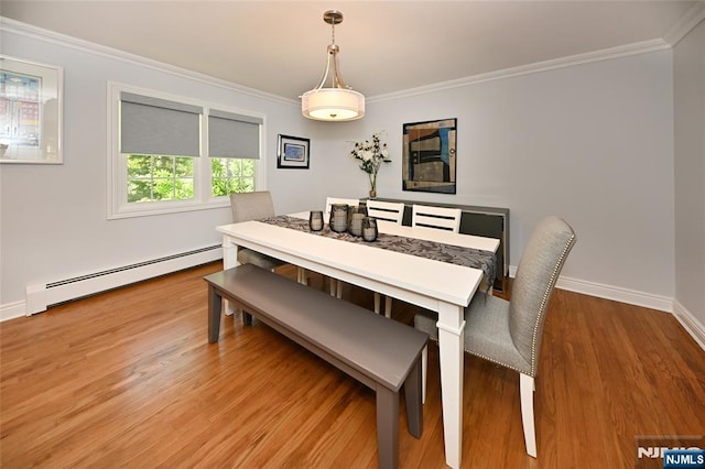 dining area featuring crown molding, a baseboard radiator, baseboards, and light wood-type flooring