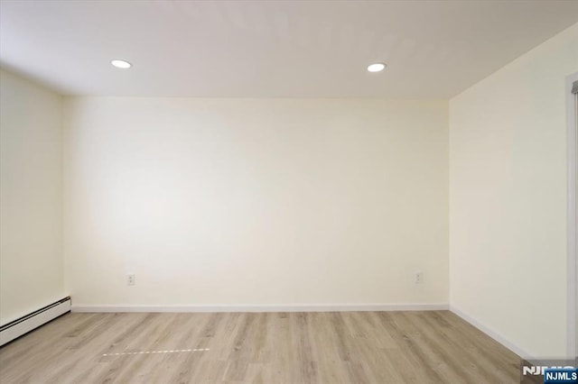 empty room with recessed lighting, baseboards, baseboard heating, and light wood-style flooring