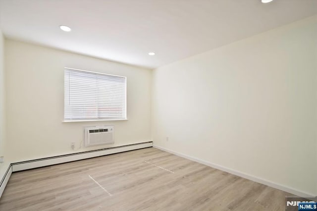 spare room with a wall unit AC, baseboards, a baseboard radiator, recessed lighting, and light wood-style flooring