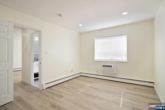 spare room with baseboards, an AC wall unit, recessed lighting, a baseboard radiator, and light wood finished floors