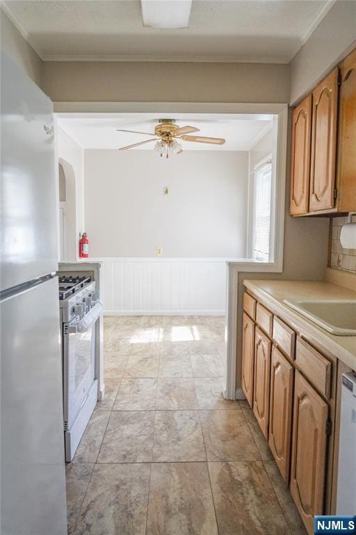 kitchen featuring gas stove, light countertops, freestanding refrigerator, a ceiling fan, and dishwashing machine