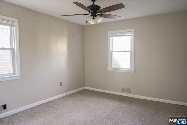 spare room featuring visible vents, a ceiling fan, baseboards, and carpet floors