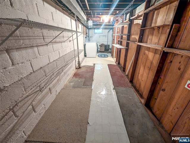 interior space featuring concrete block wall and washer / clothes dryer