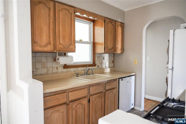 kitchen with freestanding refrigerator, backsplash, a sink, and dishwashing machine