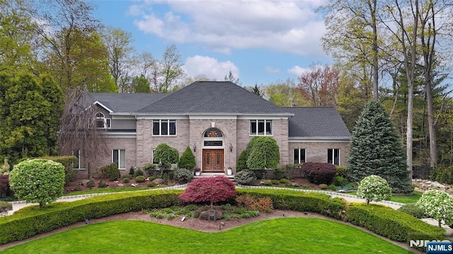 view of front of property with a front lawn and brick siding