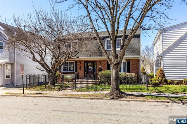 444 Washington St, Carlstadt, NJ 07072 - view of front facade featuring brick siding, roof with shingles, and a fenced front yard