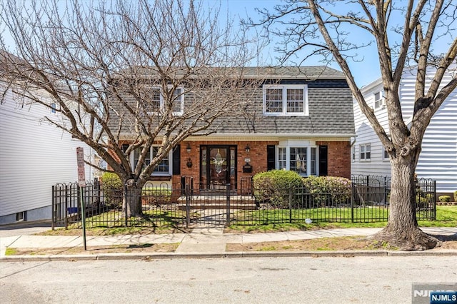 444 Washington St, Carlstadt, NJ 07072 - view of front facade with brick siding, a gambrel roof, roof with shingles, a fenced front yard, and a gate