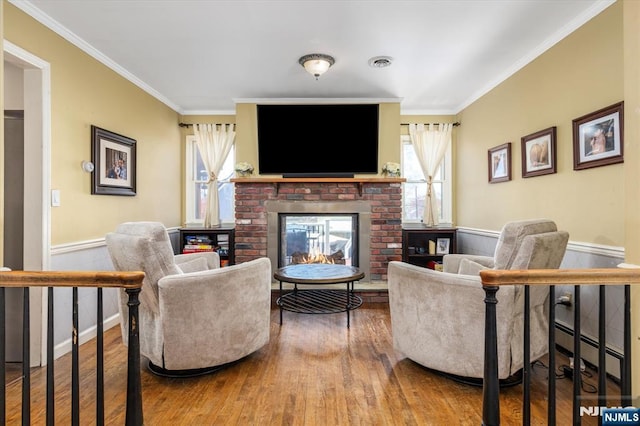 444 Washington St, Carlstadt, NJ 07072 - living area featuring a brick fireplace, crown molding, baseboard heating, wood finished floors, and healthy amount of natural light