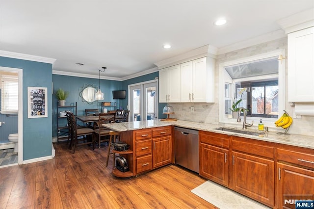 444 Washington St, Carlstadt, NJ 07072 - kitchen with dishwasher, a sink, a peninsula, wood finished floors, and light stone counters