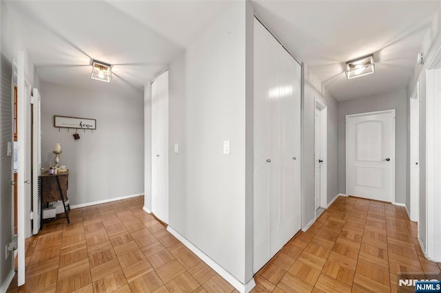 hallway featuring baseboards and visible vents