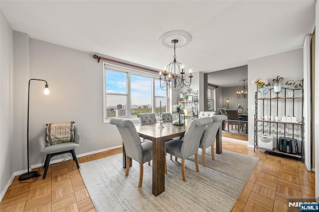 dining space featuring baseboards and a chandelier