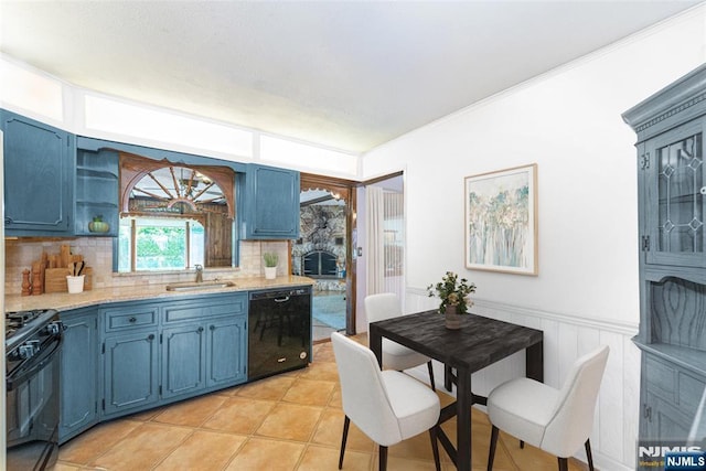 kitchen with a sink, light countertops, blue cabinetry, decorative backsplash, and black appliances