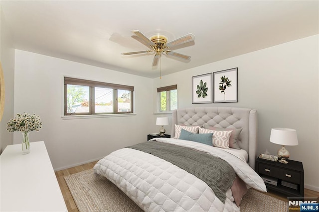 bedroom featuring a ceiling fan, baseboards, and light wood finished floors