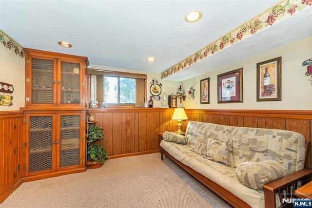 carpeted living room with recessed lighting, wood walls, and wainscoting