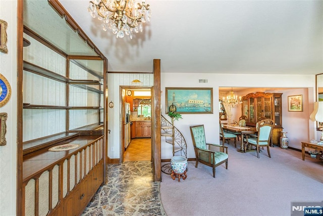 corridor with visible vents, carpet flooring, baseboards, and a notable chandelier