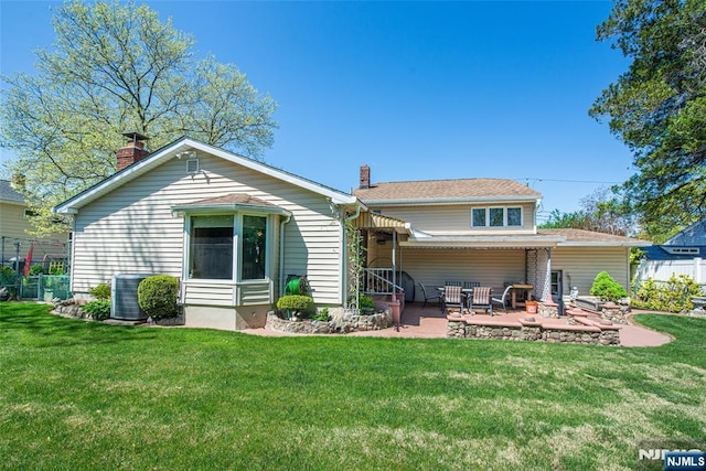 back of house featuring fence, cooling unit, a patio, a chimney, and a lawn