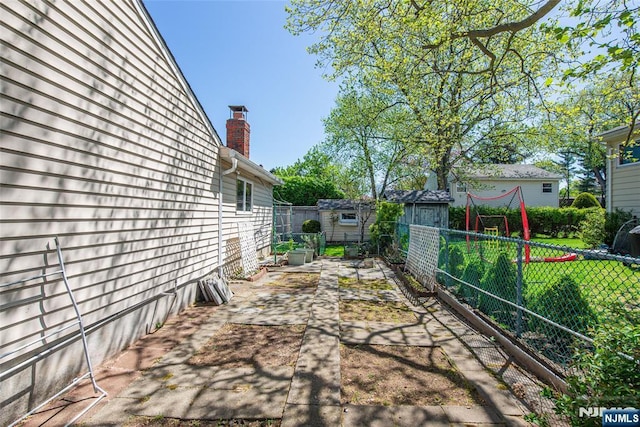 view of patio with fence, a storage unit, and an outdoor structure