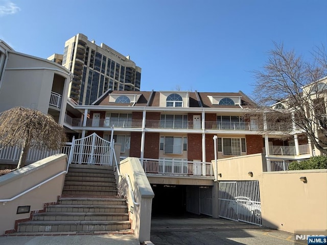 view of building exterior with an attached garage and stairway